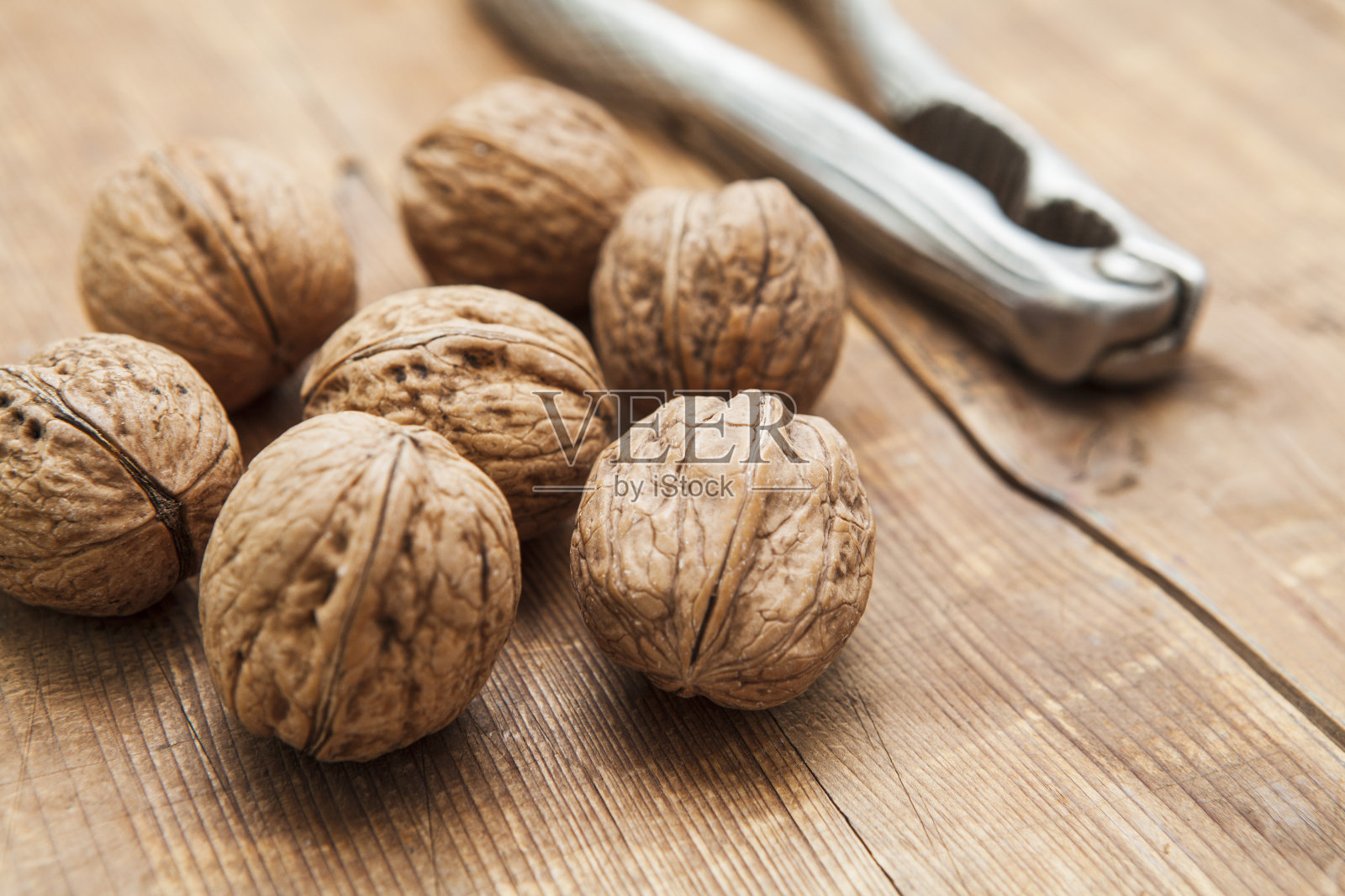胡桃和金属坚果夹在粗糙的木头表面照片摄影图片
