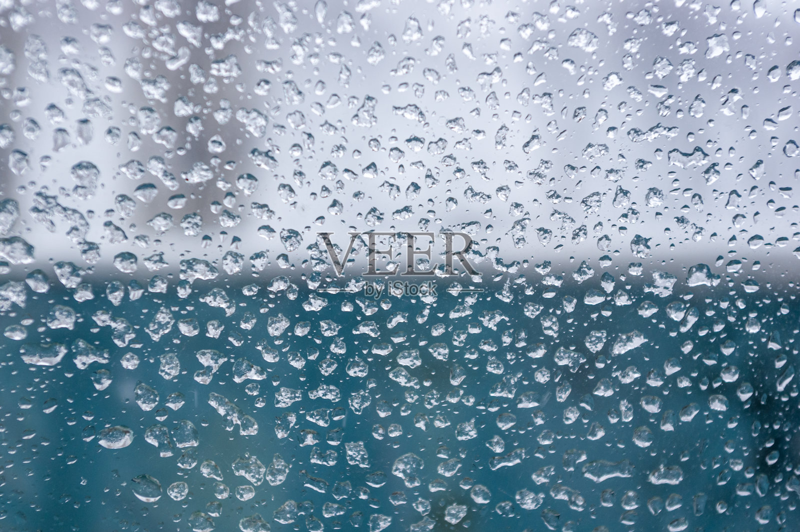 雪在玻璃上融化,水珠凝结在窗户上,透明的玻璃在寒冷的冬天,窗外的冬季景观,特写。照片摄影图片