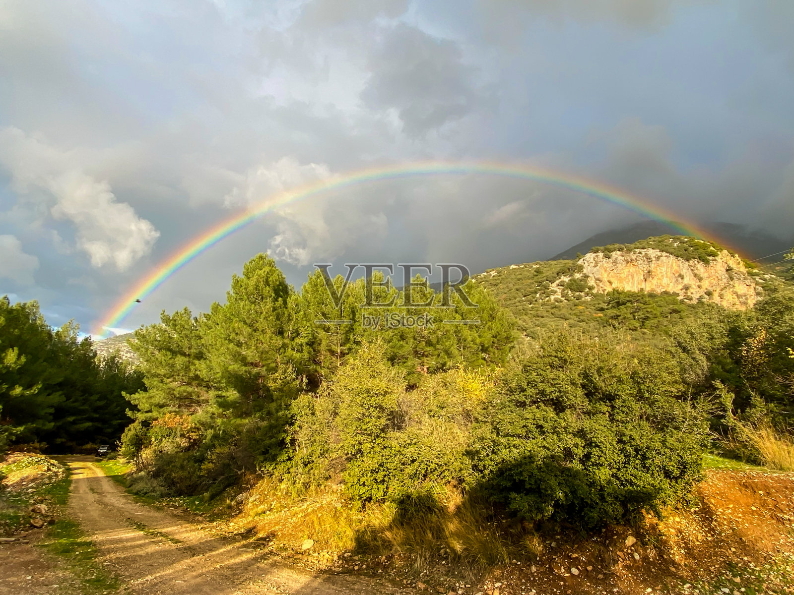 山上小路上的彩虹和多云的天空景色照片摄影图片