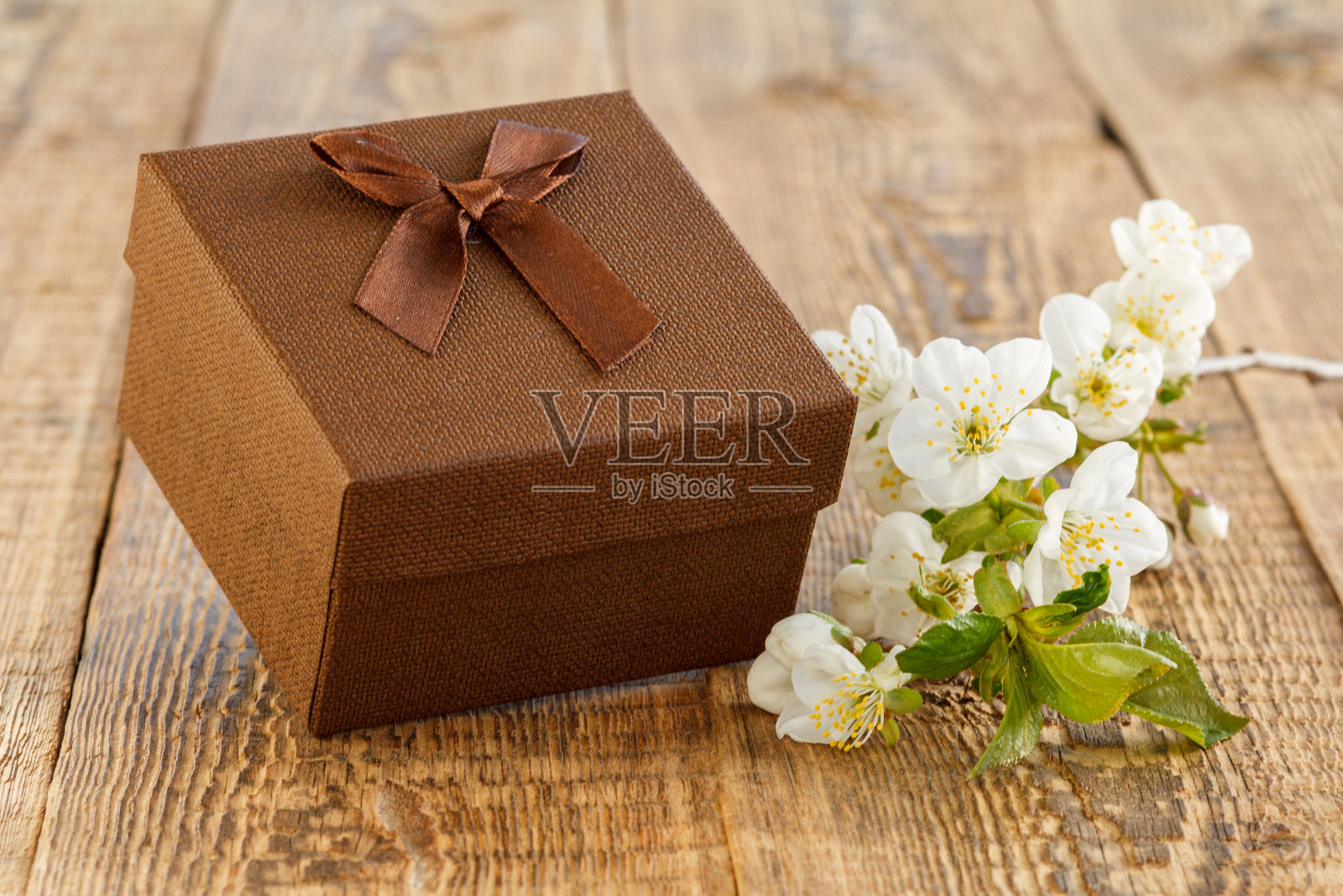 木制背景上有花的礼盒。照片摄影图片