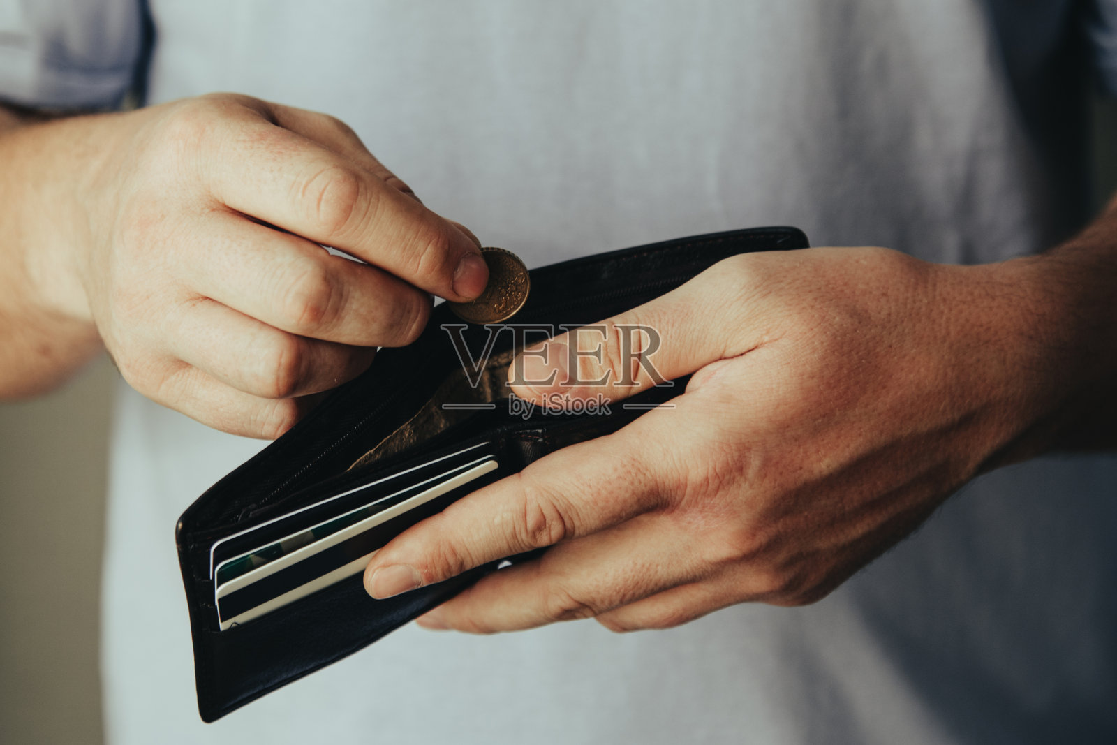 钱包在一个破产的人手里。手放一枚硬币。贫困概念,危机。照片摄影图片