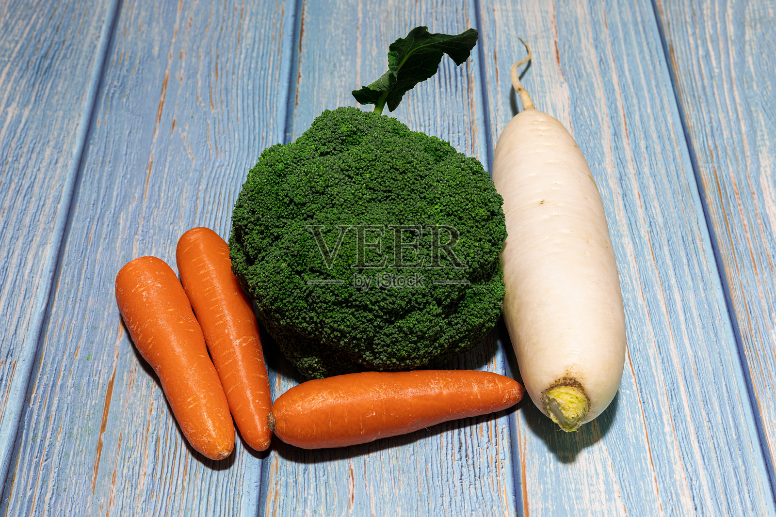 新鲜的绿色花椰菜,胡萝卜和白萝卜放在质朴的木桌上照片摄影图片