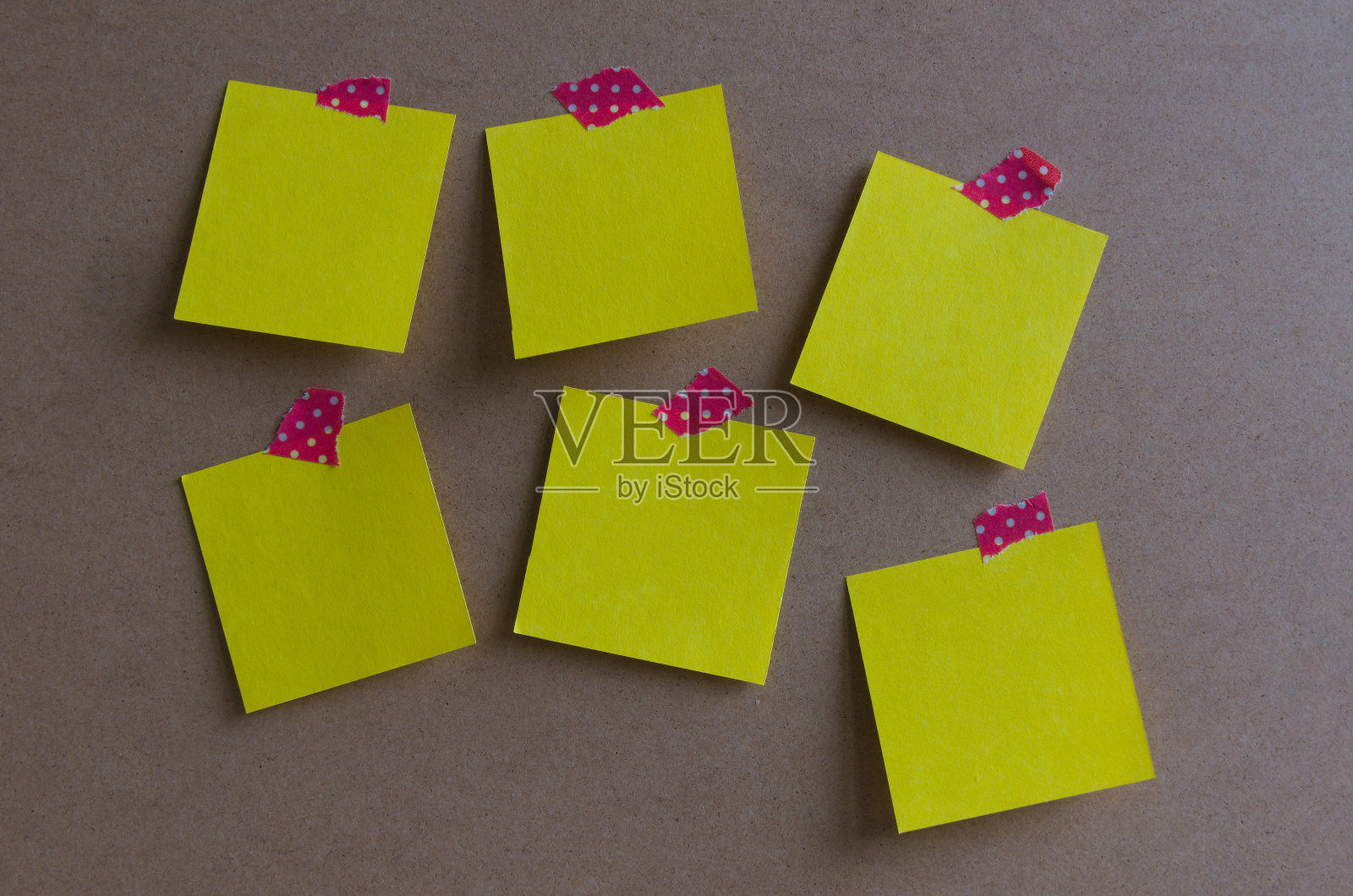 六张黄色的方形纸贴在一块红白色的带点胶带上照片摄影图片