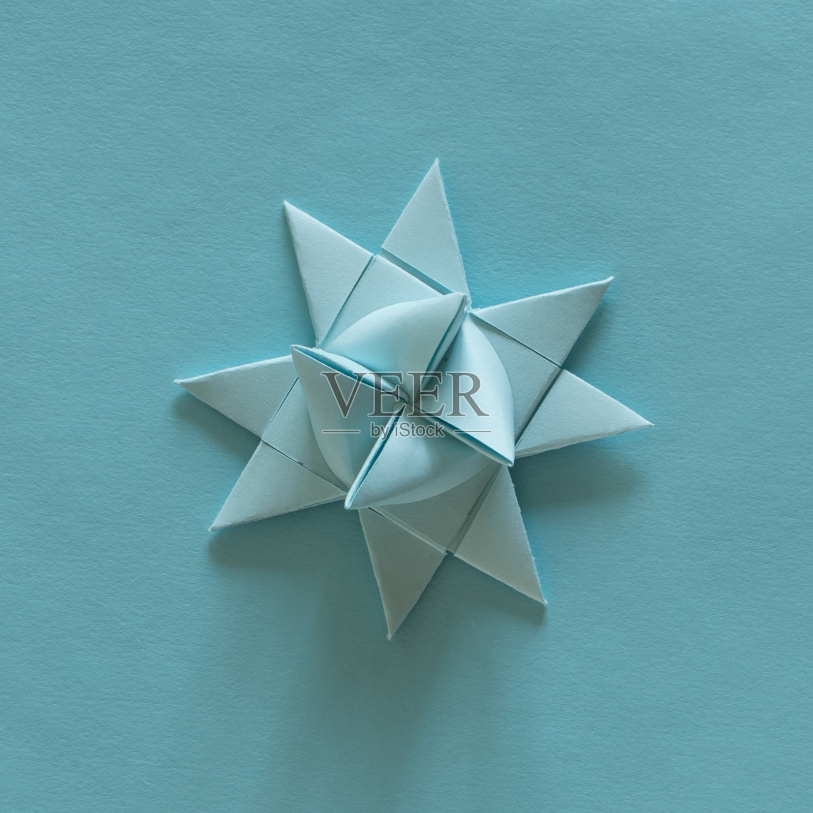 折纸3D星星,浅蓝色,浅蓝色背景。照片摄影图片