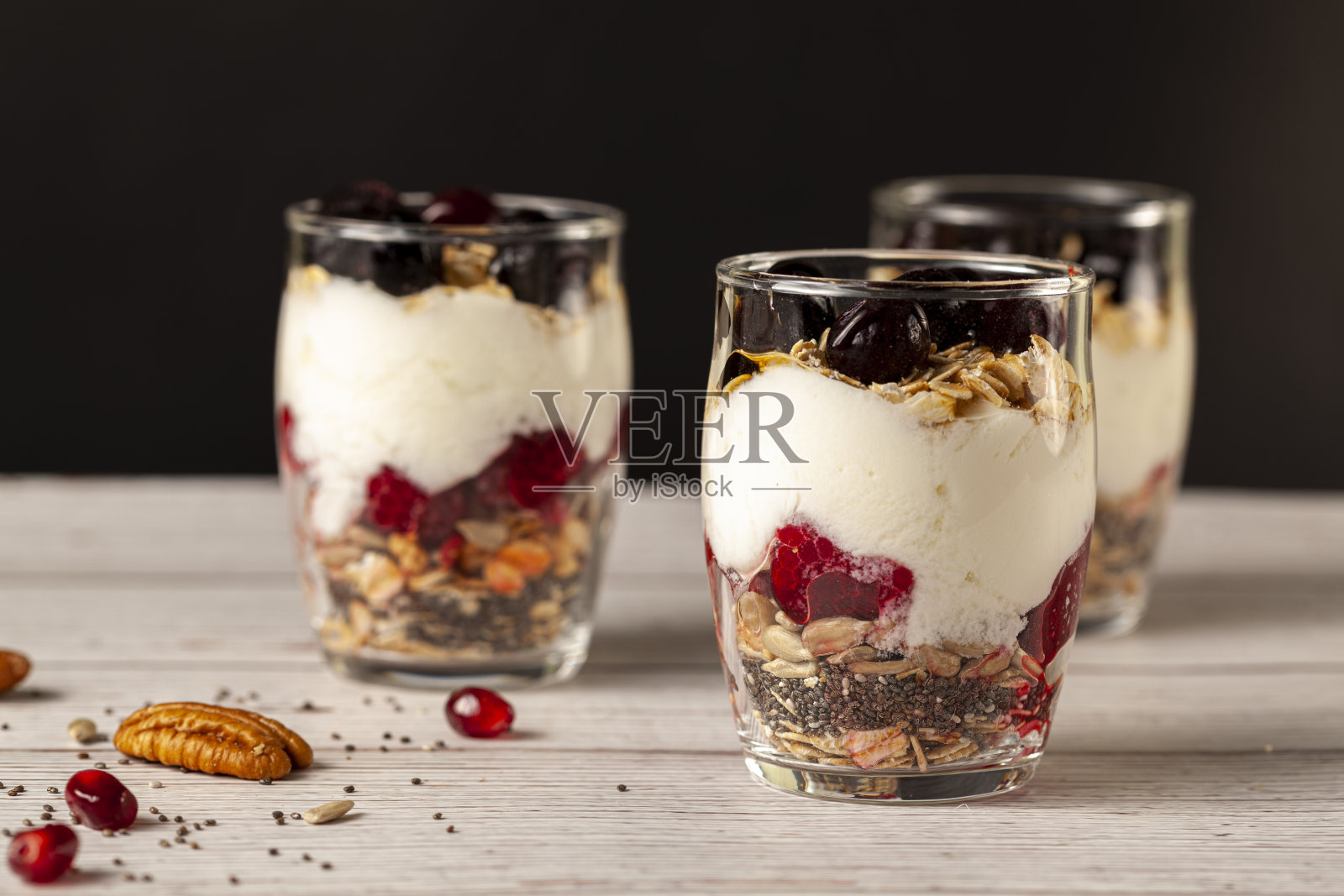 美味的水果和酸奶冻杯充满了多层什锦,奇亚籽,新鲜浆果,燕麦卷,和自制酸奶照片摄影图片