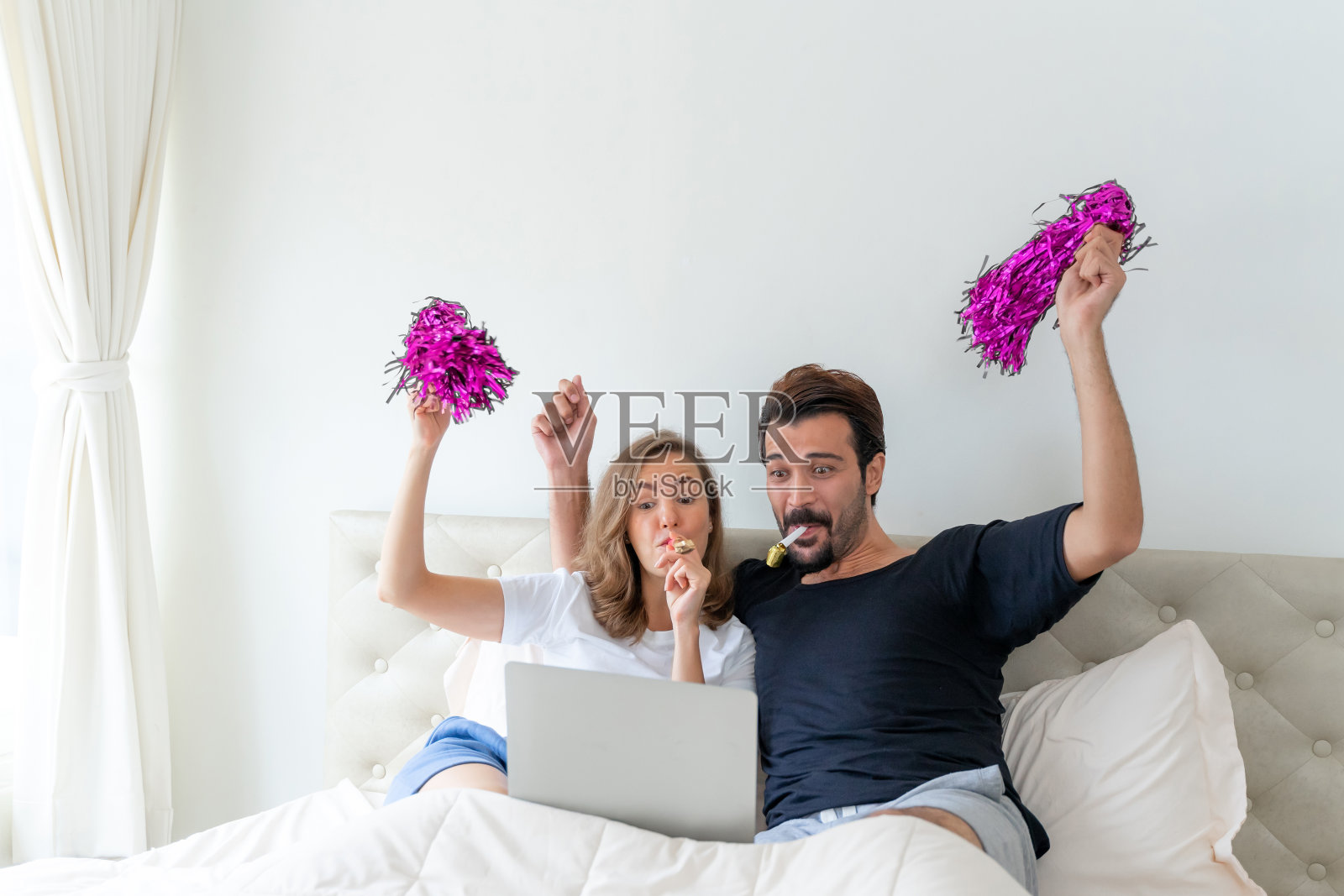 英俊的丈夫和美丽的妻子感到伟大时,他们欢呼的足球是冠军在卧室照片摄影图片