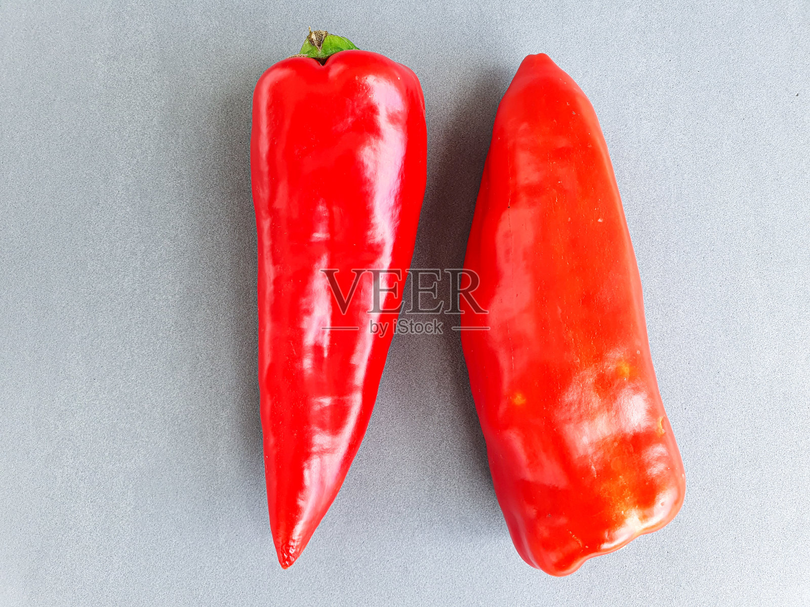 灰色背景下分离出的新鲜红辣椒。意大利胡椒照片摄影图片