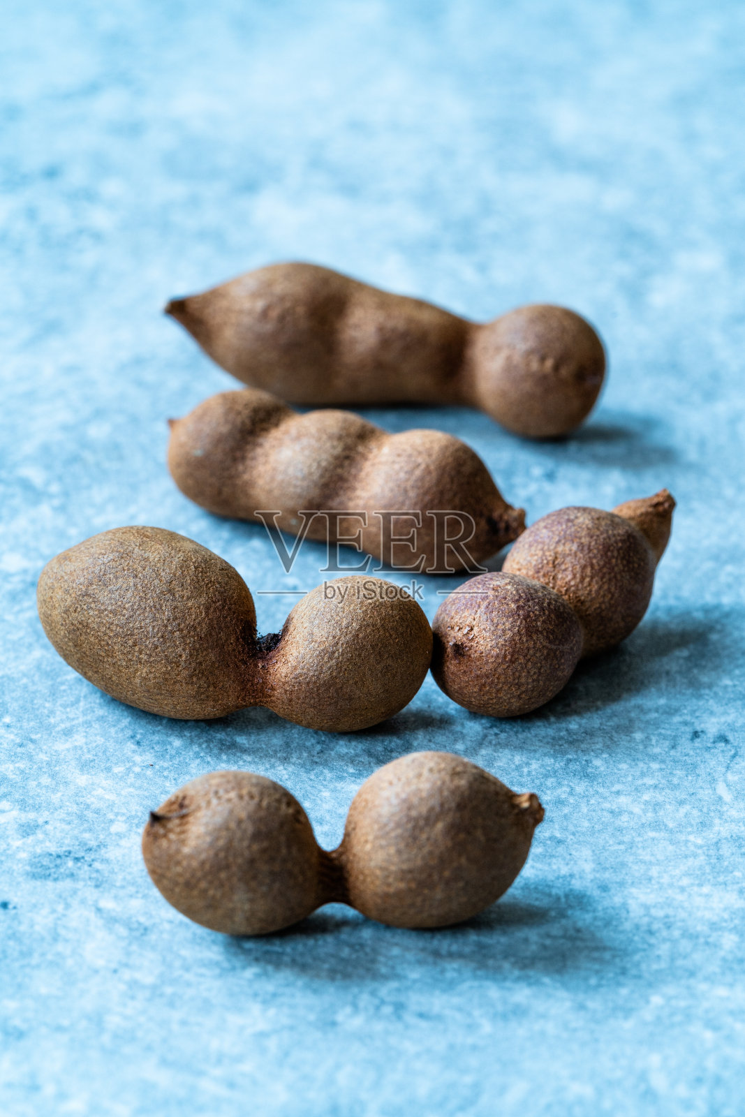 一堆成熟的甜罗望子果带壳。照片摄影图片