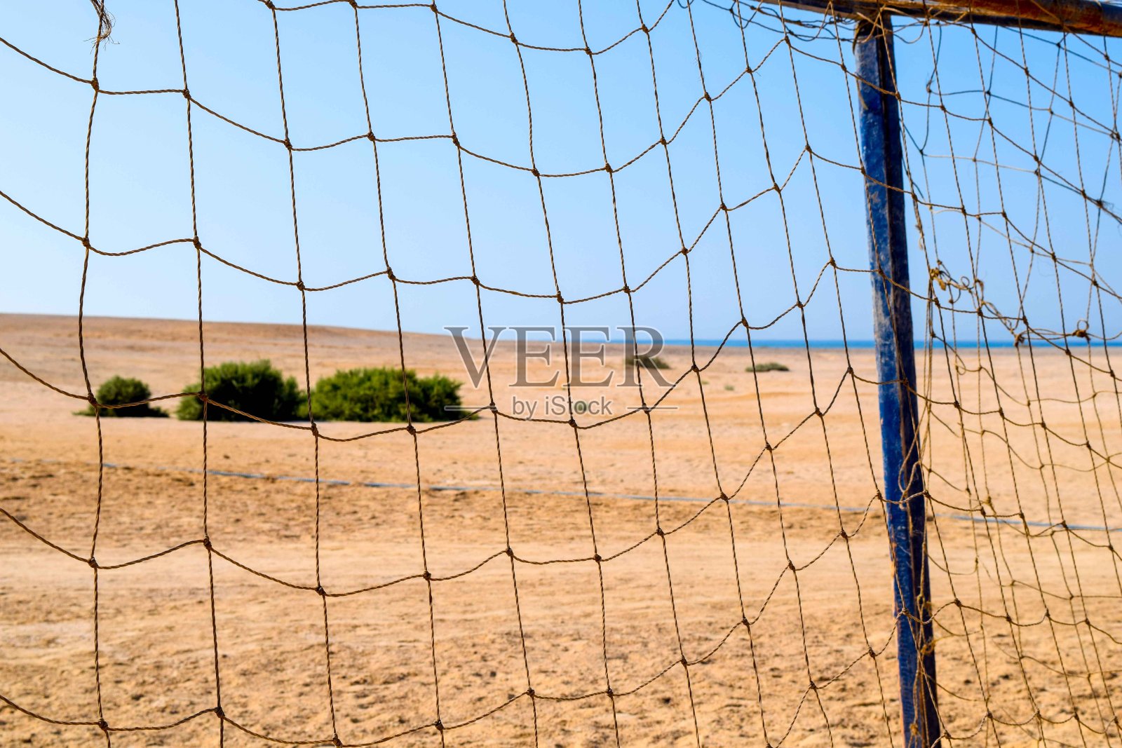 透过足球球门网看到的沙滩景色照片摄影图片