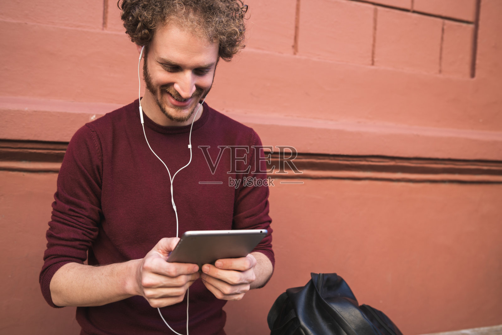 在户外使用数码平板电脑的男人。照片摄影图片