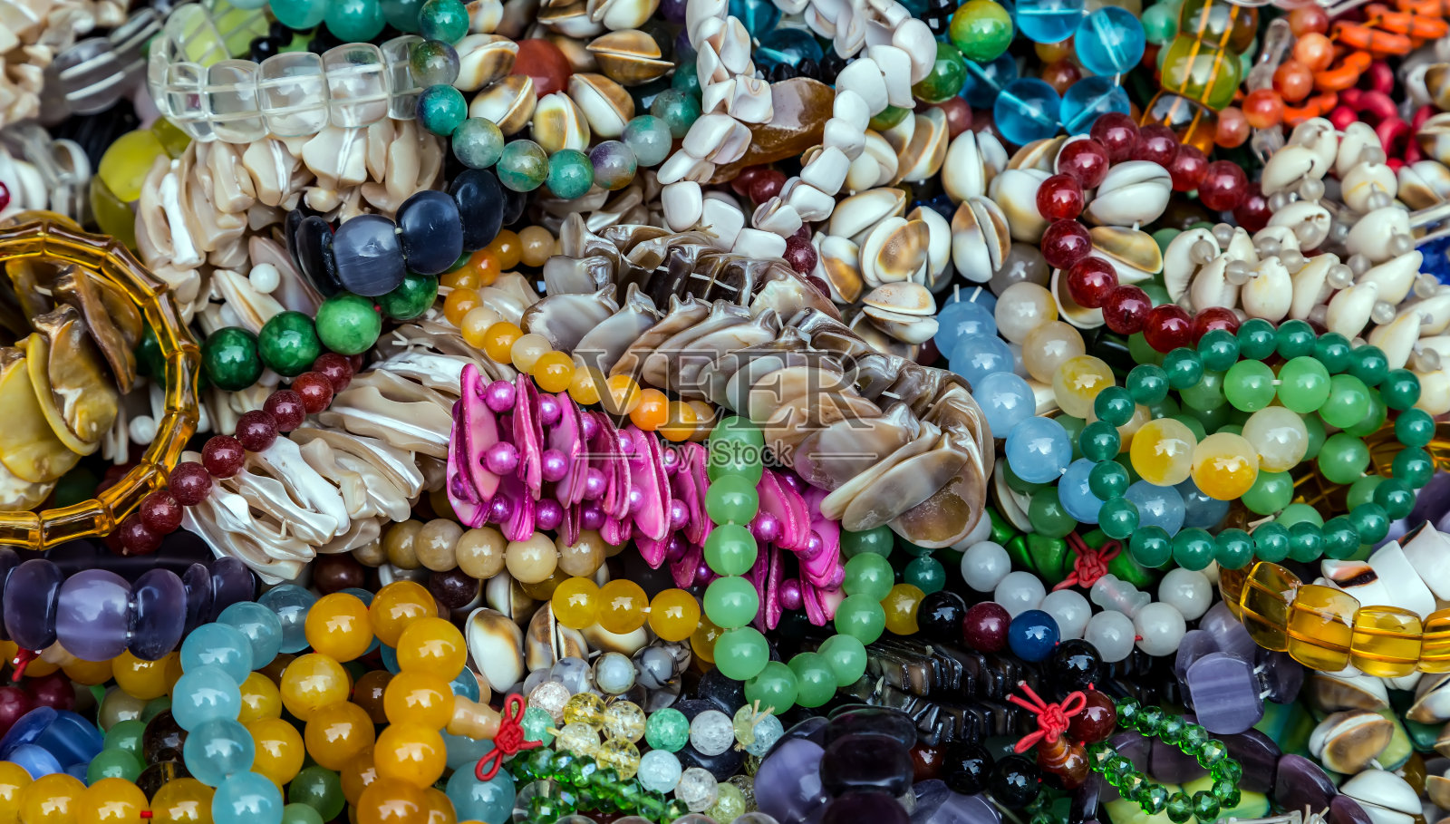 女性现代配饰多彩的手链。照片摄影图片