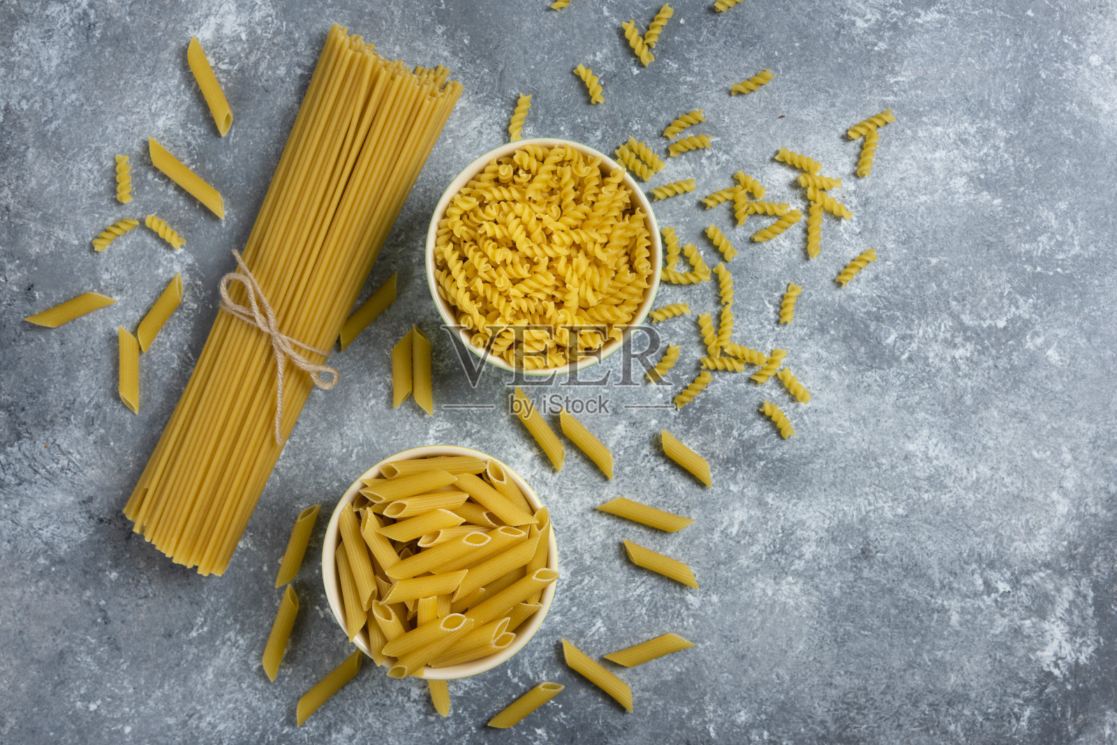 大理石背景上放着不同种类的生通心粉照片摄影图片
