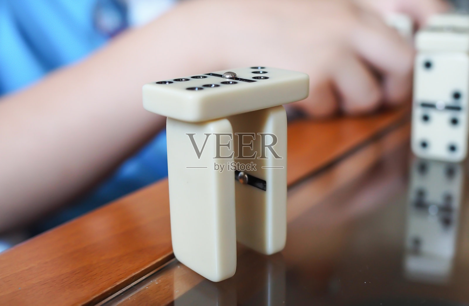 一个面目全非的孩子在玩多米诺骨牌。关闭了。儿童与游戏概念照片摄影图片