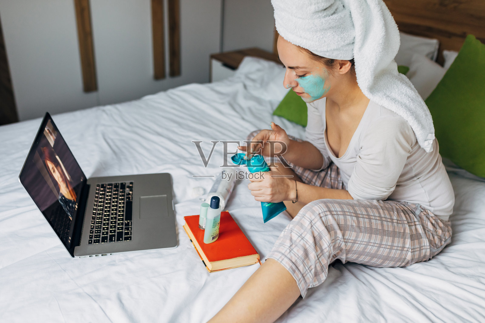 年轻女子在隔离期间在家享受虚拟水疗和美容,同时通过视频电话与家人保持联系照片摄影图片