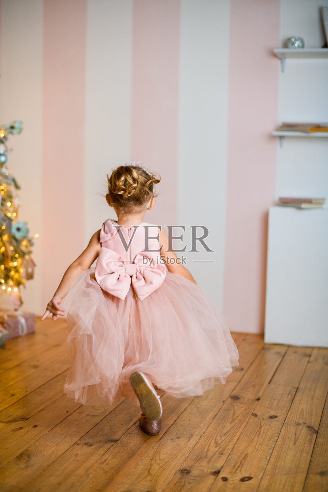 全长小女孩的后视图在美丽的粉红色连衣裙与领结照片摄影图片