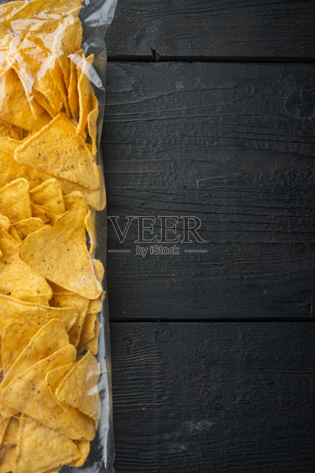 玉米脆饼袋,在黑色的木制背景,俯视图或平躺与文本复制空间照片摄影图片