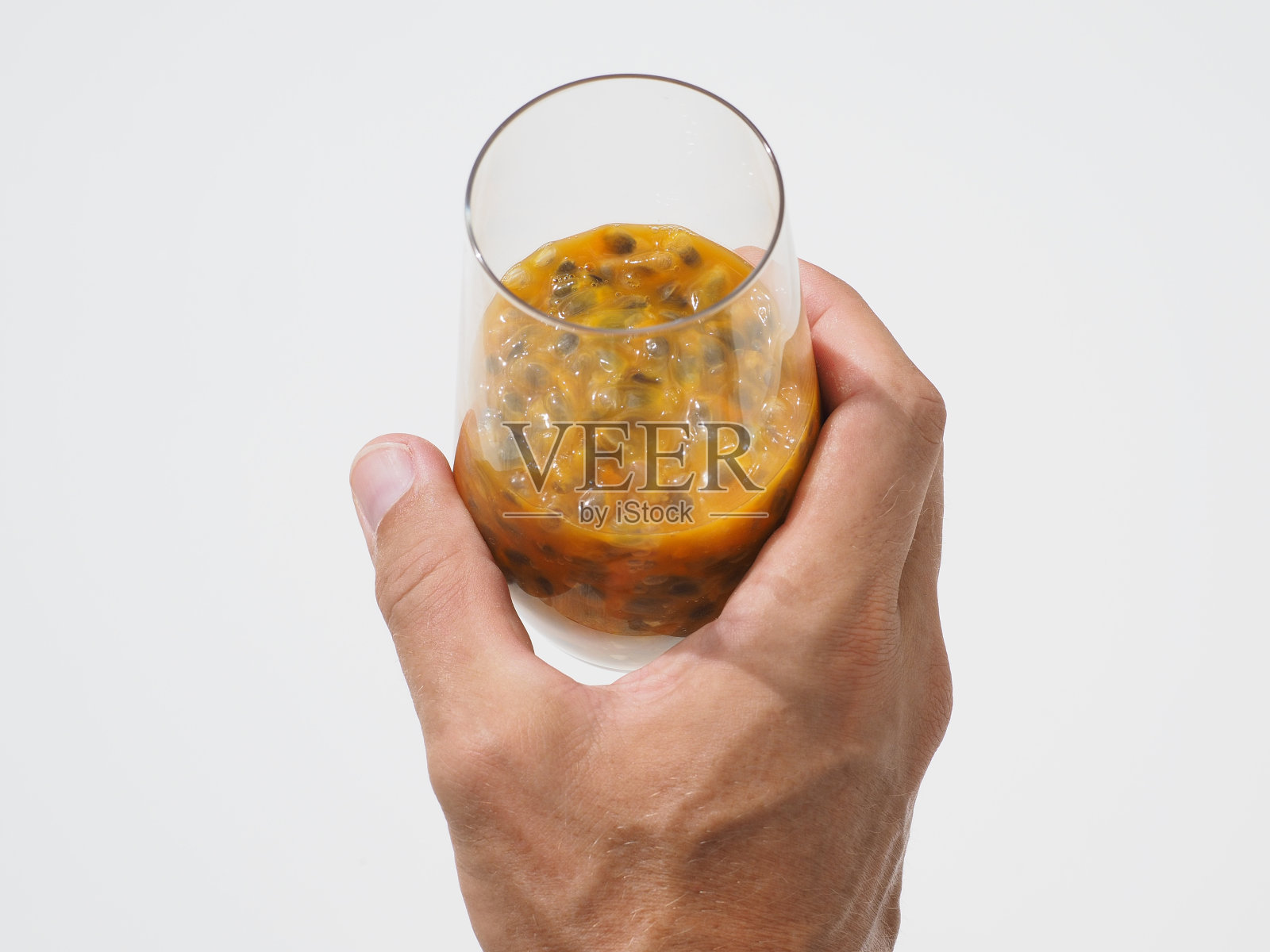 手持玻璃与新鲜的百香果(maracuya)果汁。特写镜头。照片摄影图片