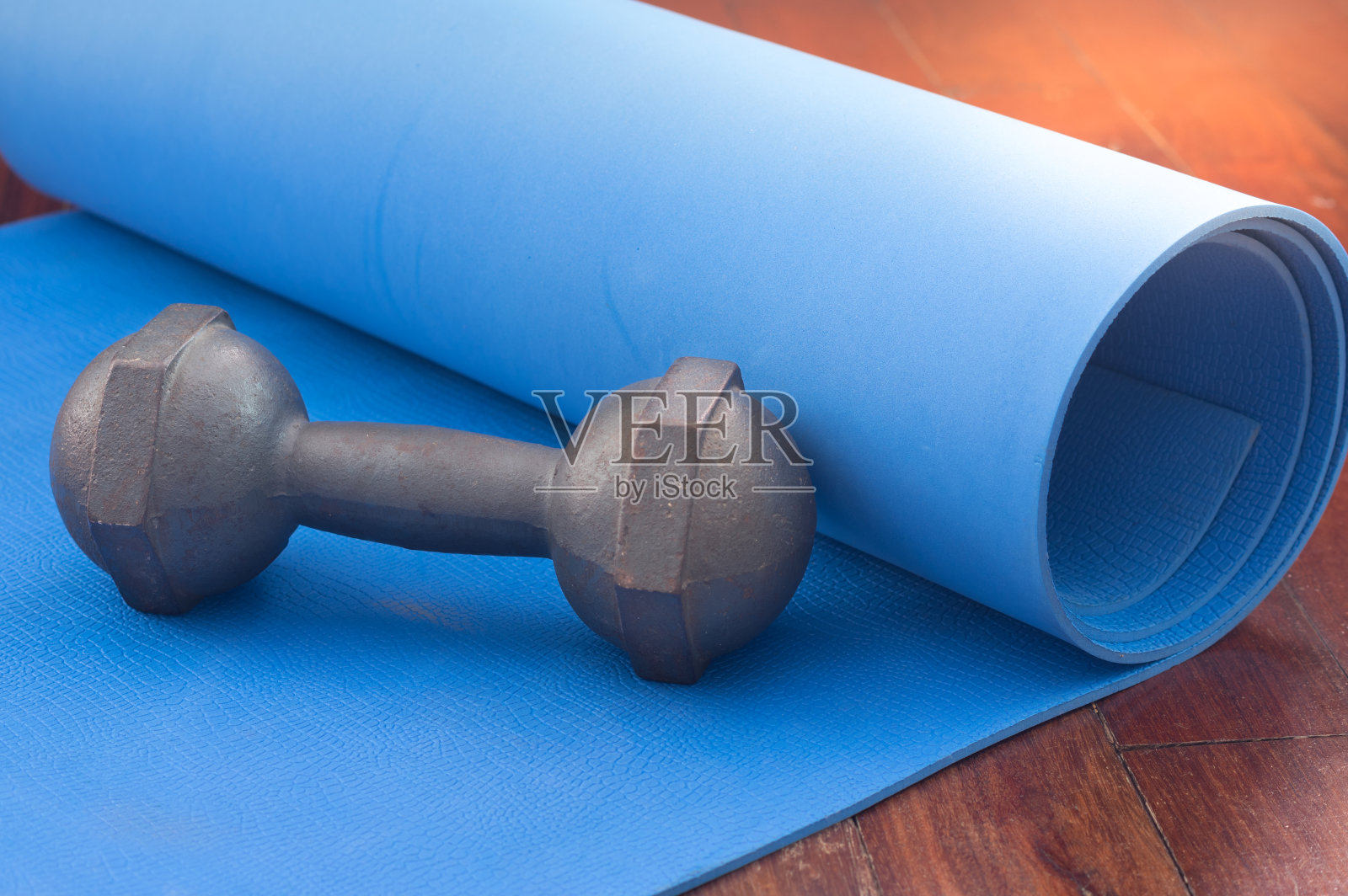 瑜伽垫上的金属哑铃。照片摄影图片