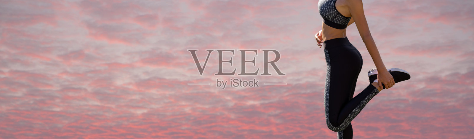 一个年轻苗条的运动女孩穿着印有蛇皮图案的运动服进行一套练习。健康的生活方式。照片摄影图片