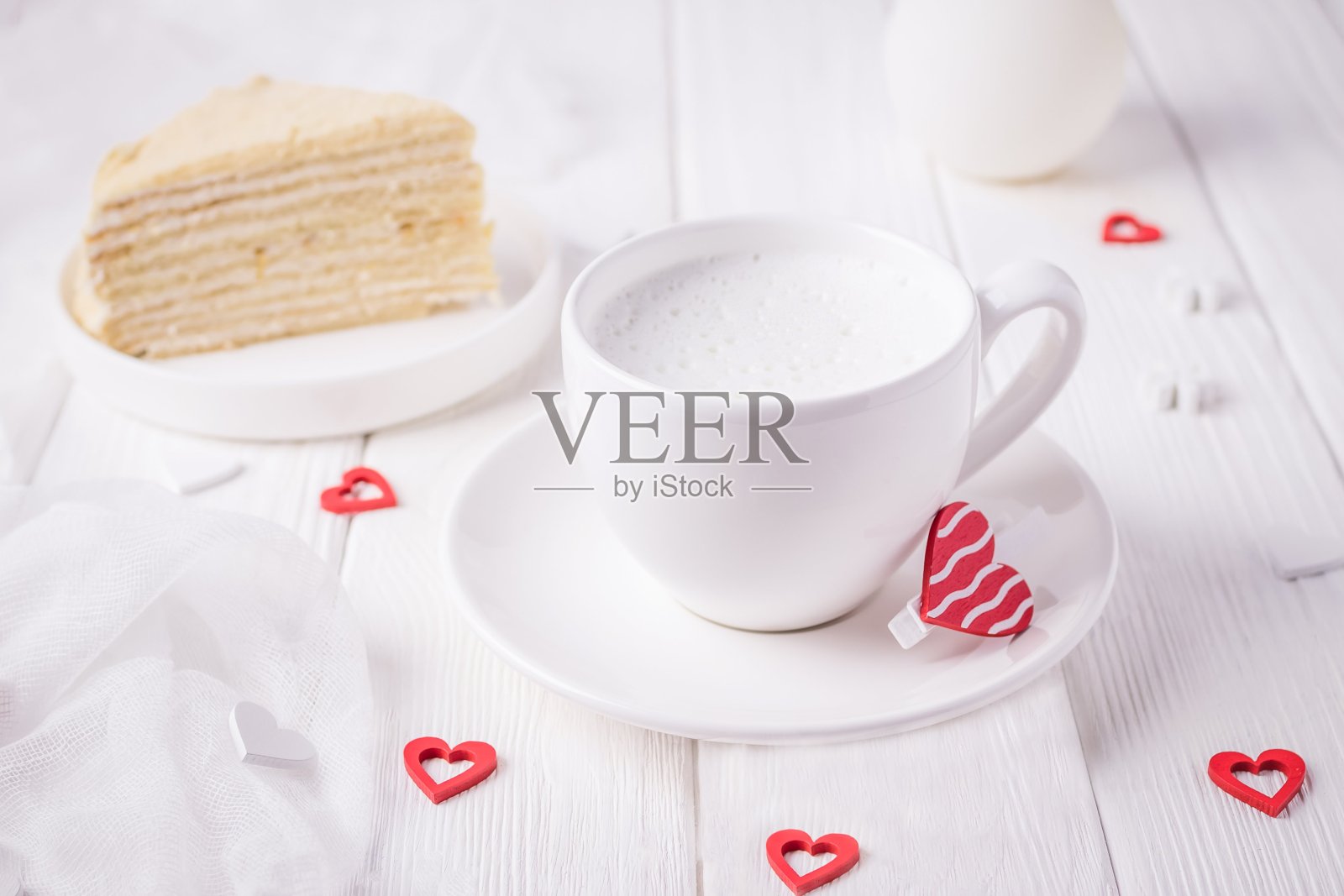 白色杯加牛奶,自制的蜂蜜蛋糕和红心照片摄影图片