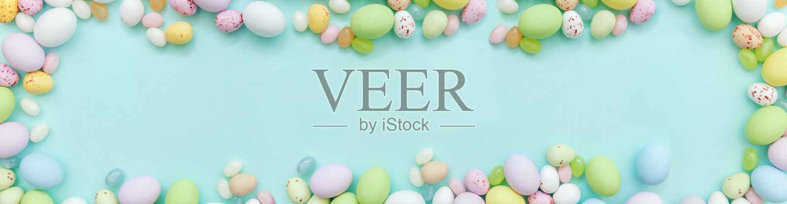复活节快乐的概念。为假期做准备。复活节糖果,巧克力蛋和软糖糖孤立在时尚柔和的蓝色背景。简单的极简主义平铺俯视图复制空间。横幅照片摄影图片