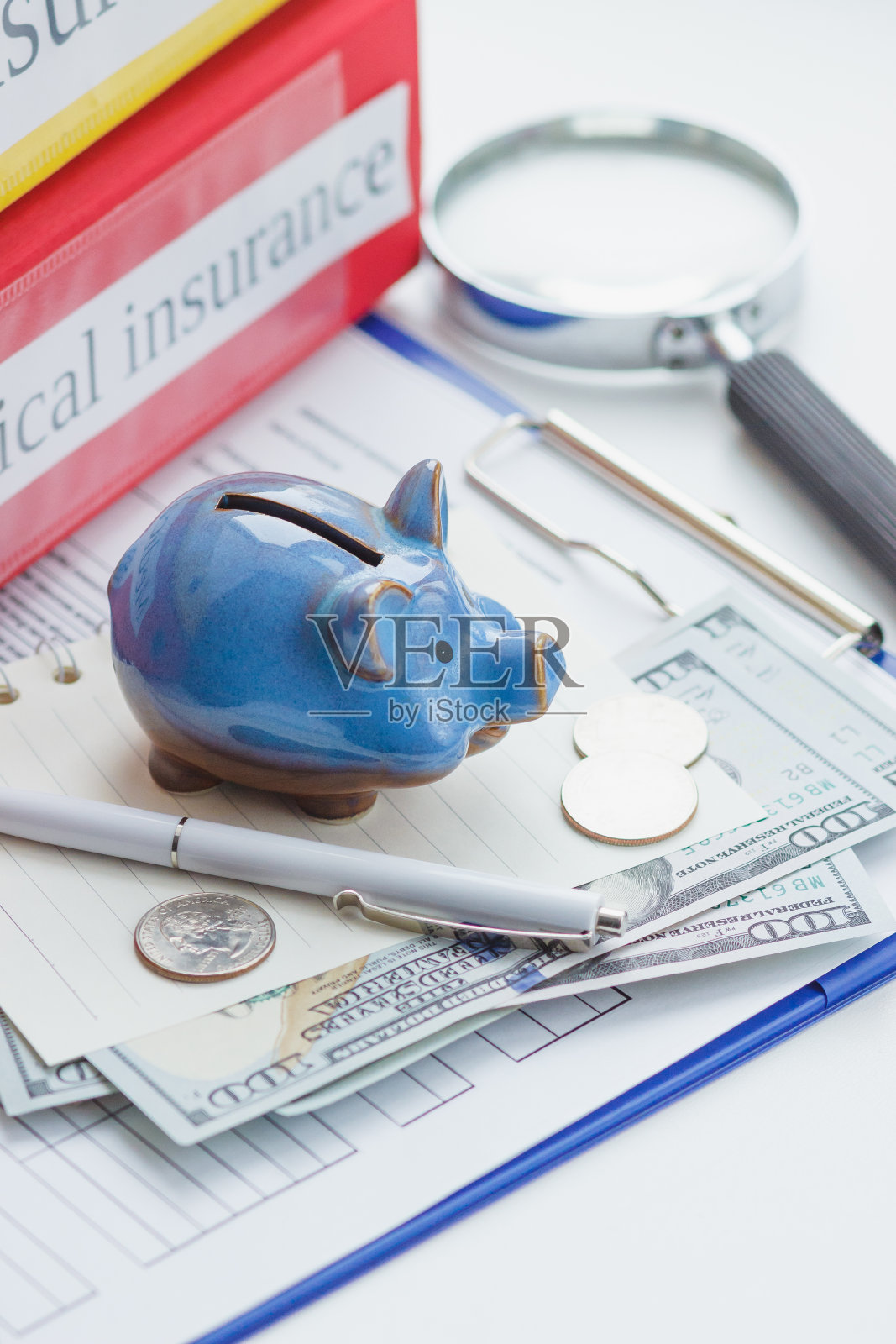 干净的保险表格,放大镜,存钱罐和钱照片摄影图片