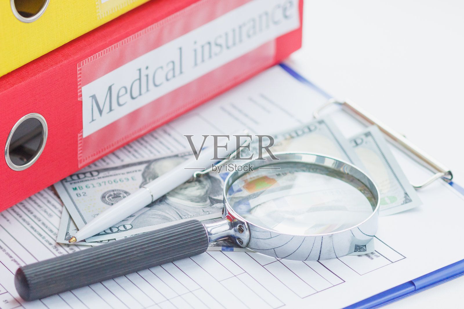干净的保险表格,钢笔,放大镜和钱照片摄影图片