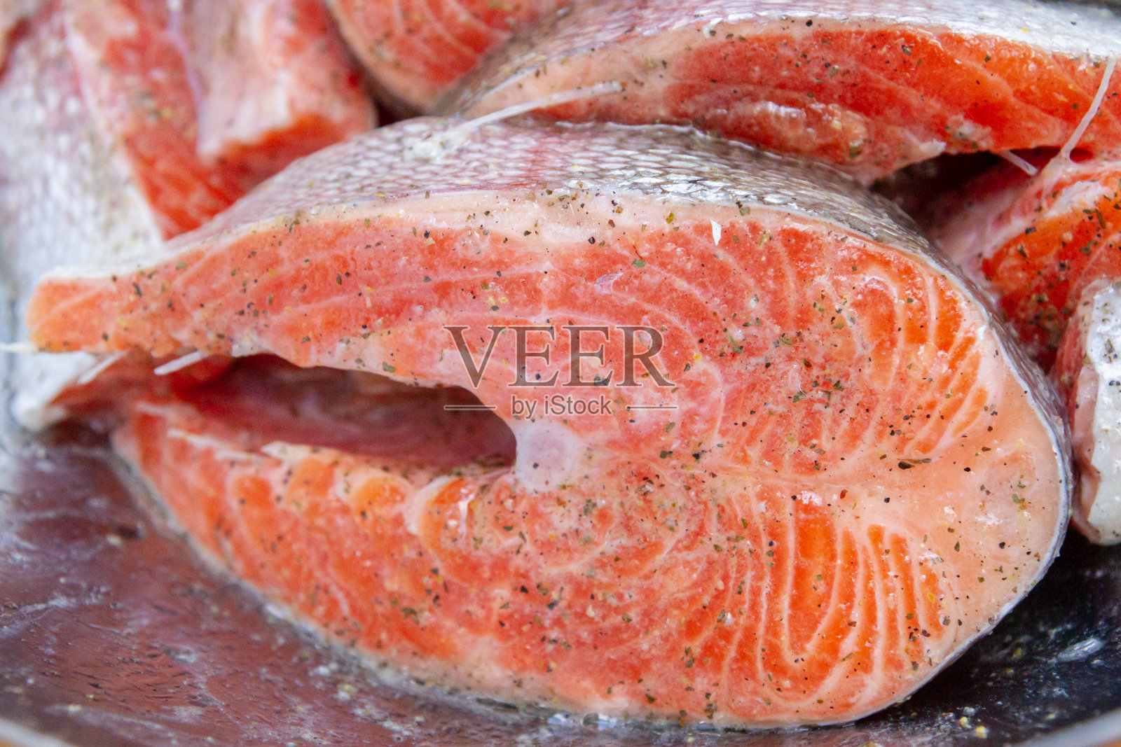 新鲜的鳟鱼排在烹饪前要浸泡在金属碗里照片摄影图片