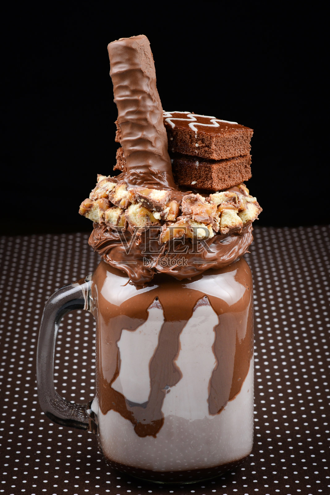 巧克力奶昔配布朗尼蛋糕,巧克力酱和糖果。疯狂的食物潮流。本空间照片摄影图片