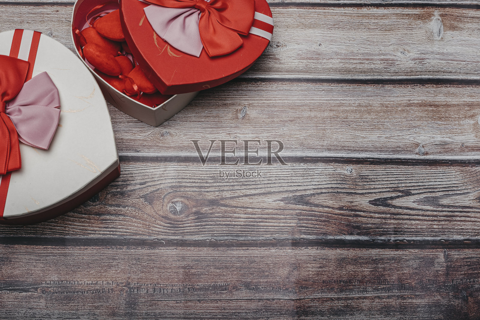 情人节贺卡。木桌上放着带蝴蝶结的心盒。顶部视图与复制空间照片摄影图片
