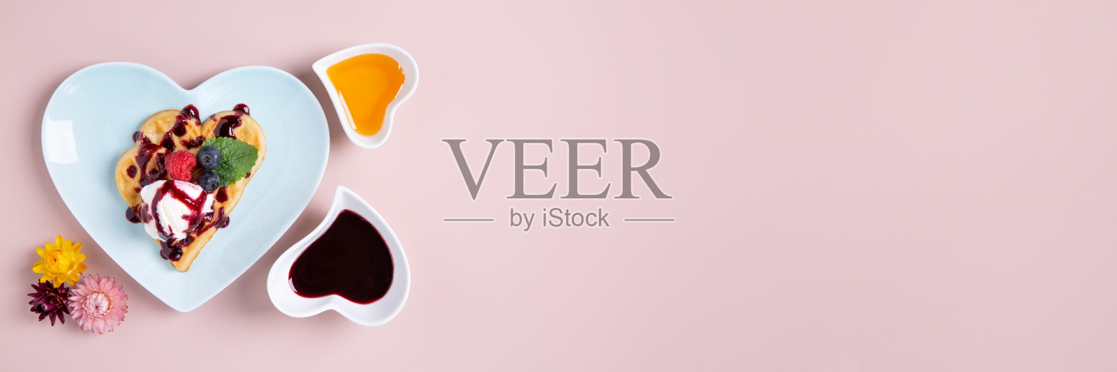 心形比利时华夫饼,粉红色背景上有冰淇淋和浆果。美味的早餐。情人节快乐。顶视图,旗帜。照片摄影图片