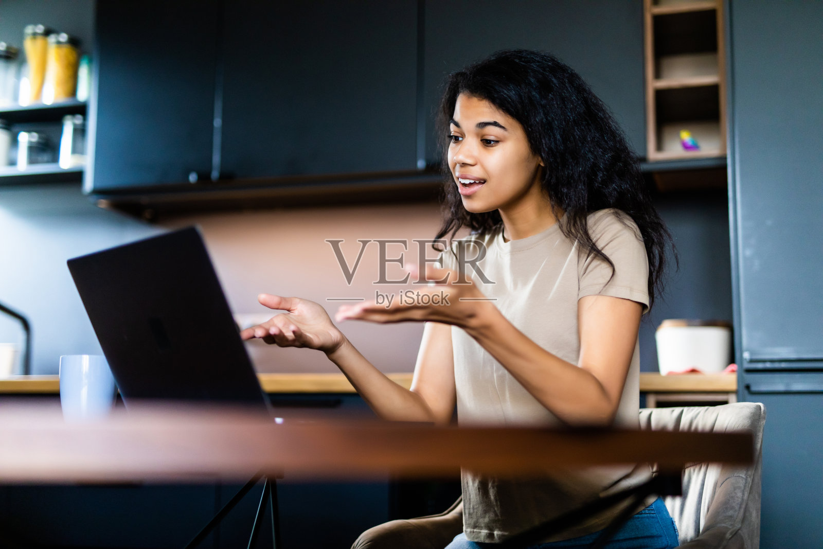 通过视频电话与朋友进行远距离沟通。一个年轻迷人的黑人妇女通过视频和她的朋友聊天,她看着摄像头,微笑着。照片摄影图片