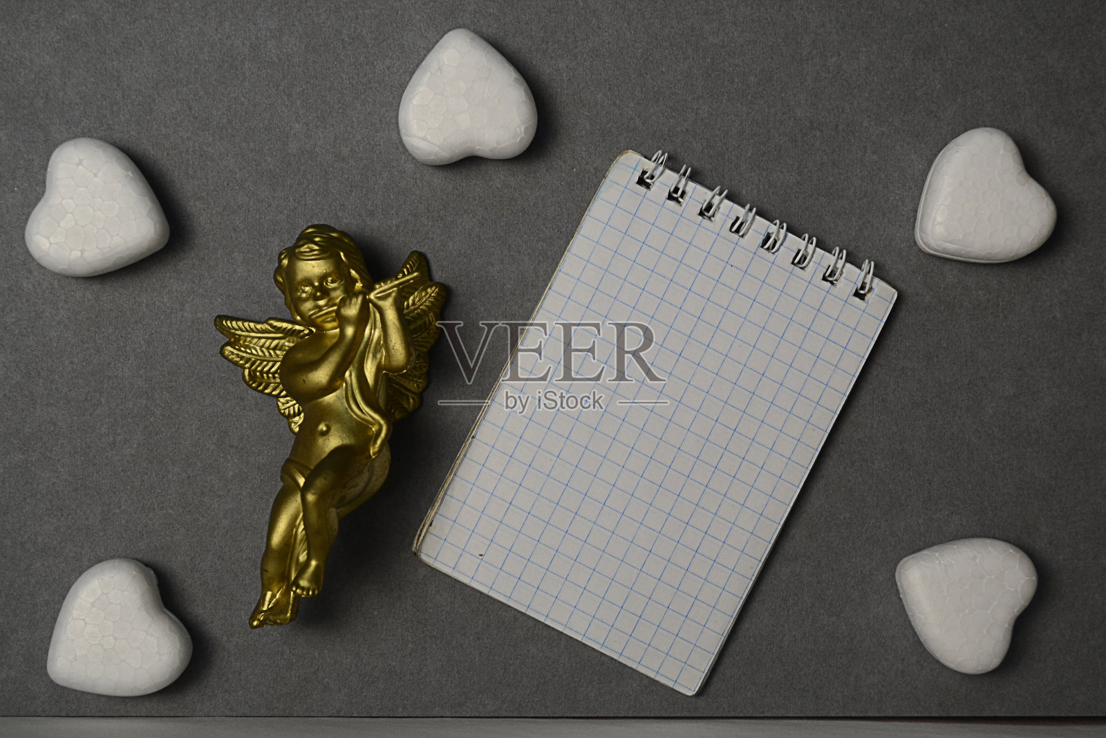 丘比特和心脏。笔记本纸。模型。情人节卡片。爱的象征。恋情。神的爱。照片摄影图片