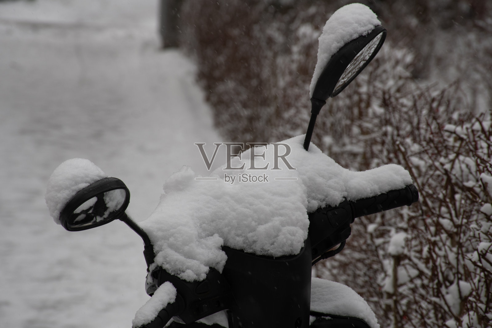 摩托车把手和覆盖着新雪的镜子照片摄影图片
