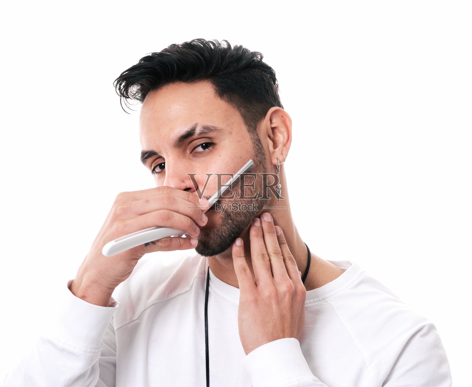 一名男子在白色背景上用剃刀刮胡须照片摄影图片