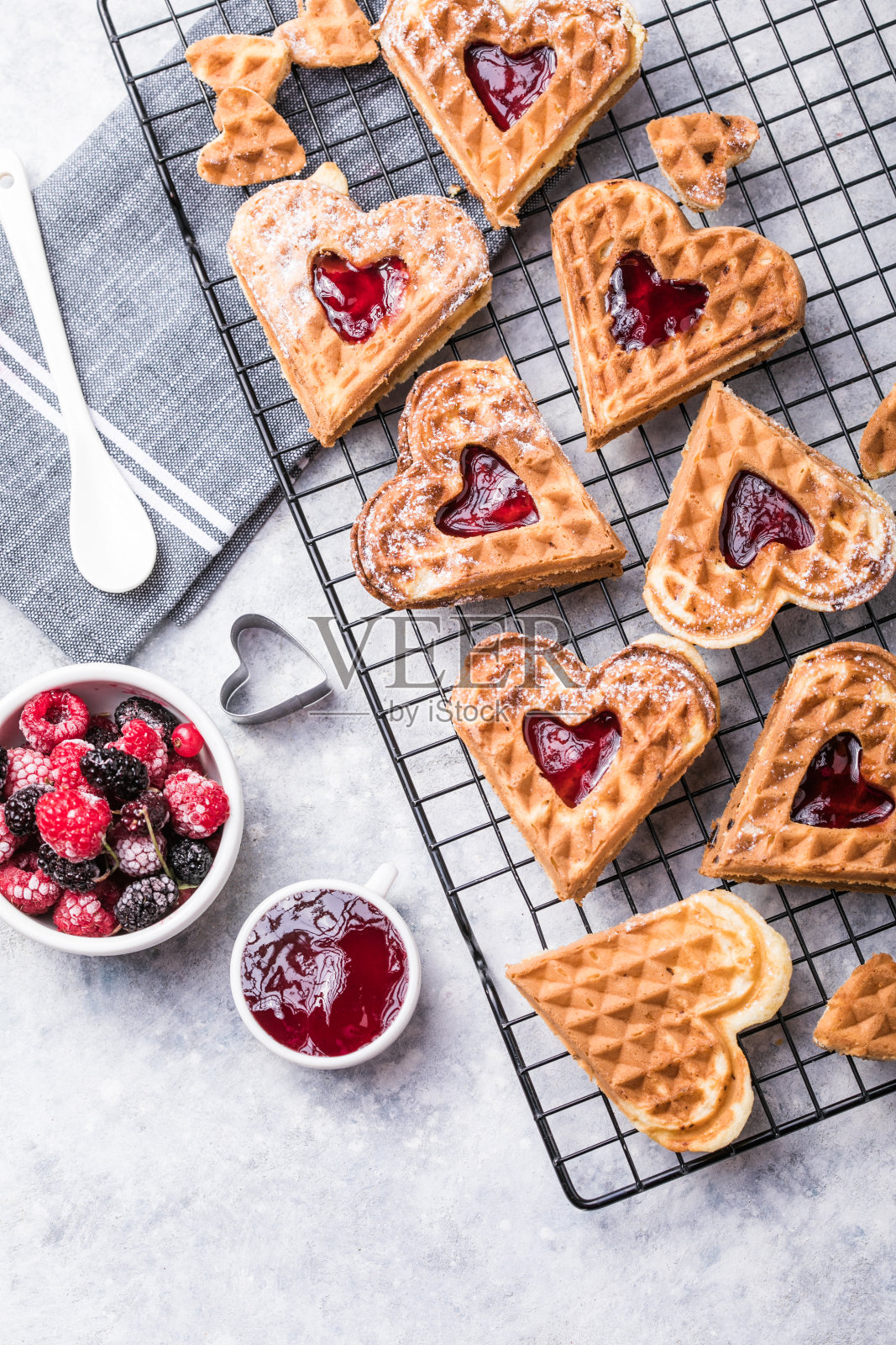 灰色背景上的新鲜自制心形比利时华夫饼。欧洲烘焙糕点。情人节早餐概念。照片摄影图片