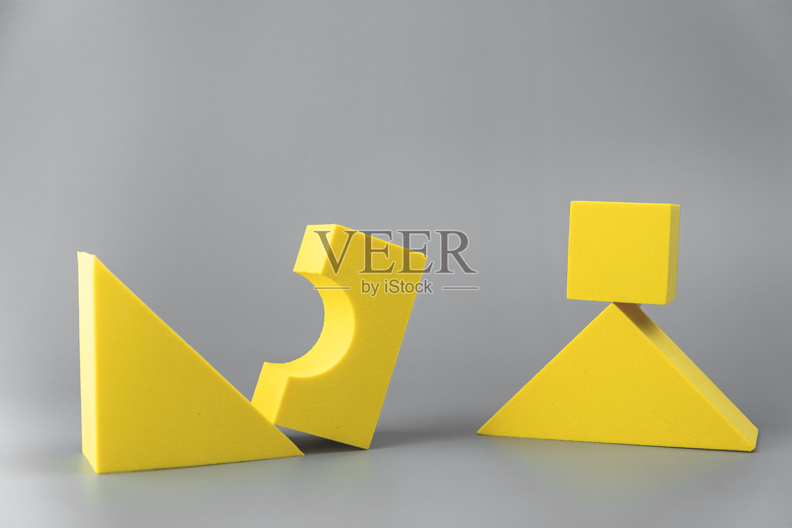 在灰色背景上的一组体积黄色几何形状。简单的形状。一个三角形边缘上的立方体照片摄影图片