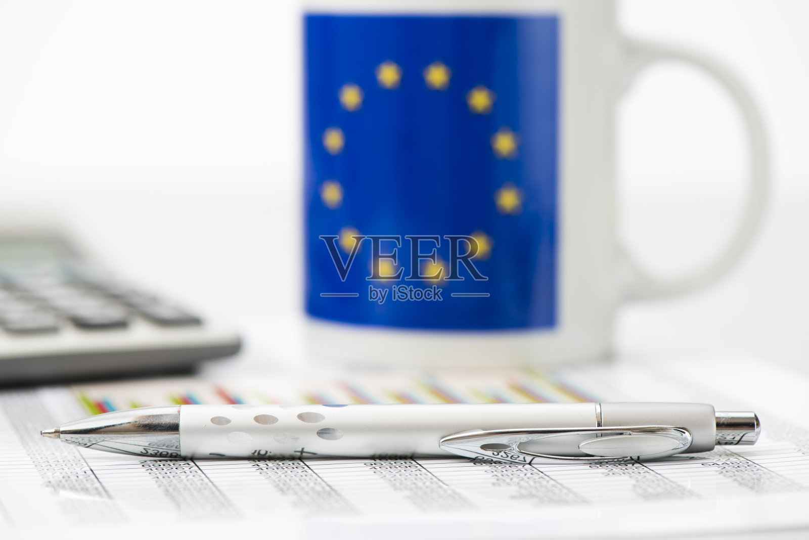 在金融数据和图表中堆砌欧元硬币照片摄影图片