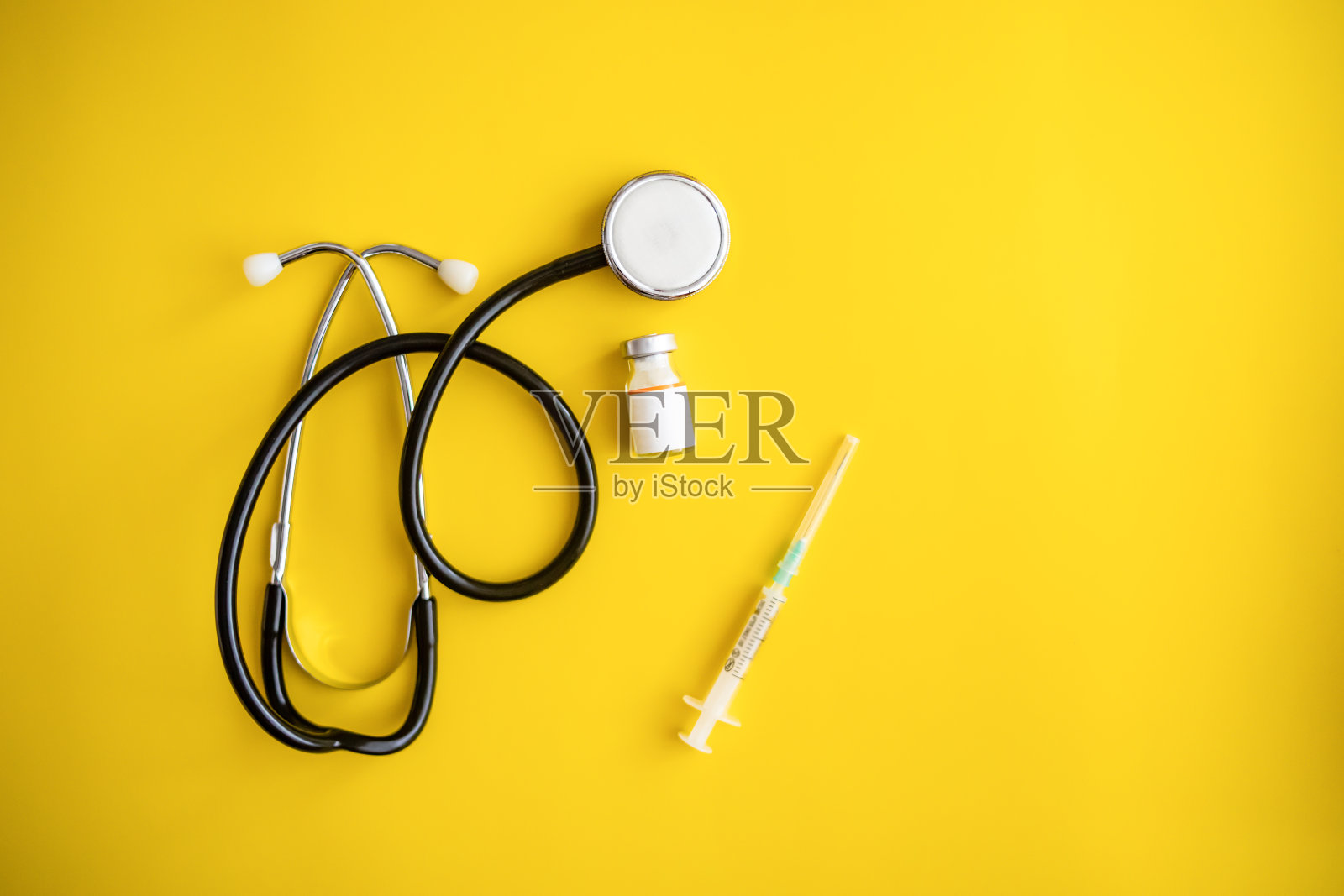 黄色背景的Covid-19冠状病毒疫苗瓶子- Covid-19疫苗治疗。新型冠状病毒疫苗瓶、注射器注射工具照片摄影图片