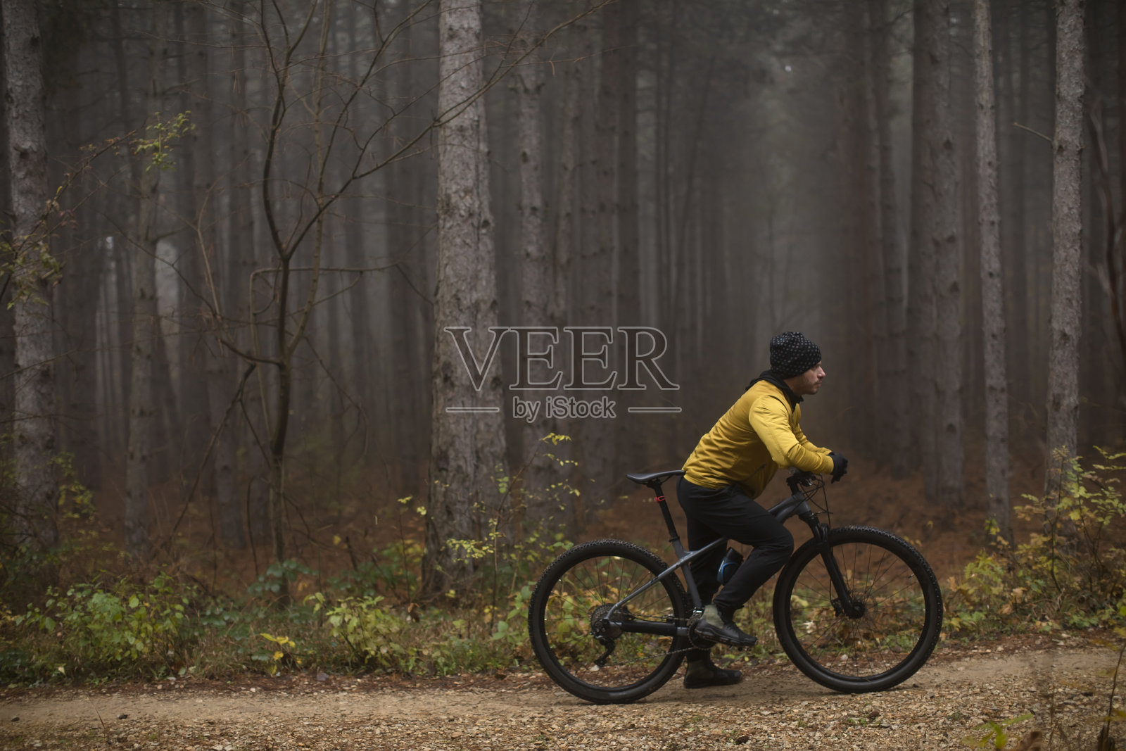 一个年轻人在骑车穿过秋天的森林时刹住了车照片摄影图片