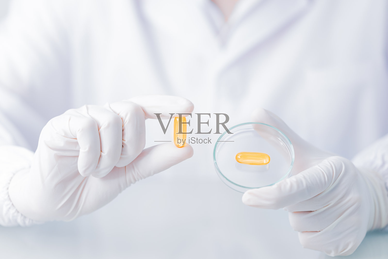 近距离的科学家拿着胶囊凝胶在实验大衣照片摄影图片