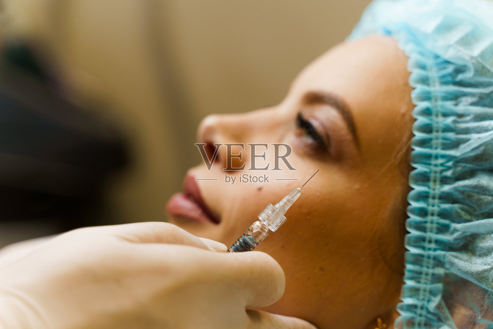 特写填充注射在颧骨。对鼻子、下巴、颧骨、太阳穴的体积和形状进行整形。美容返老还童面部治疗。照片摄影图片