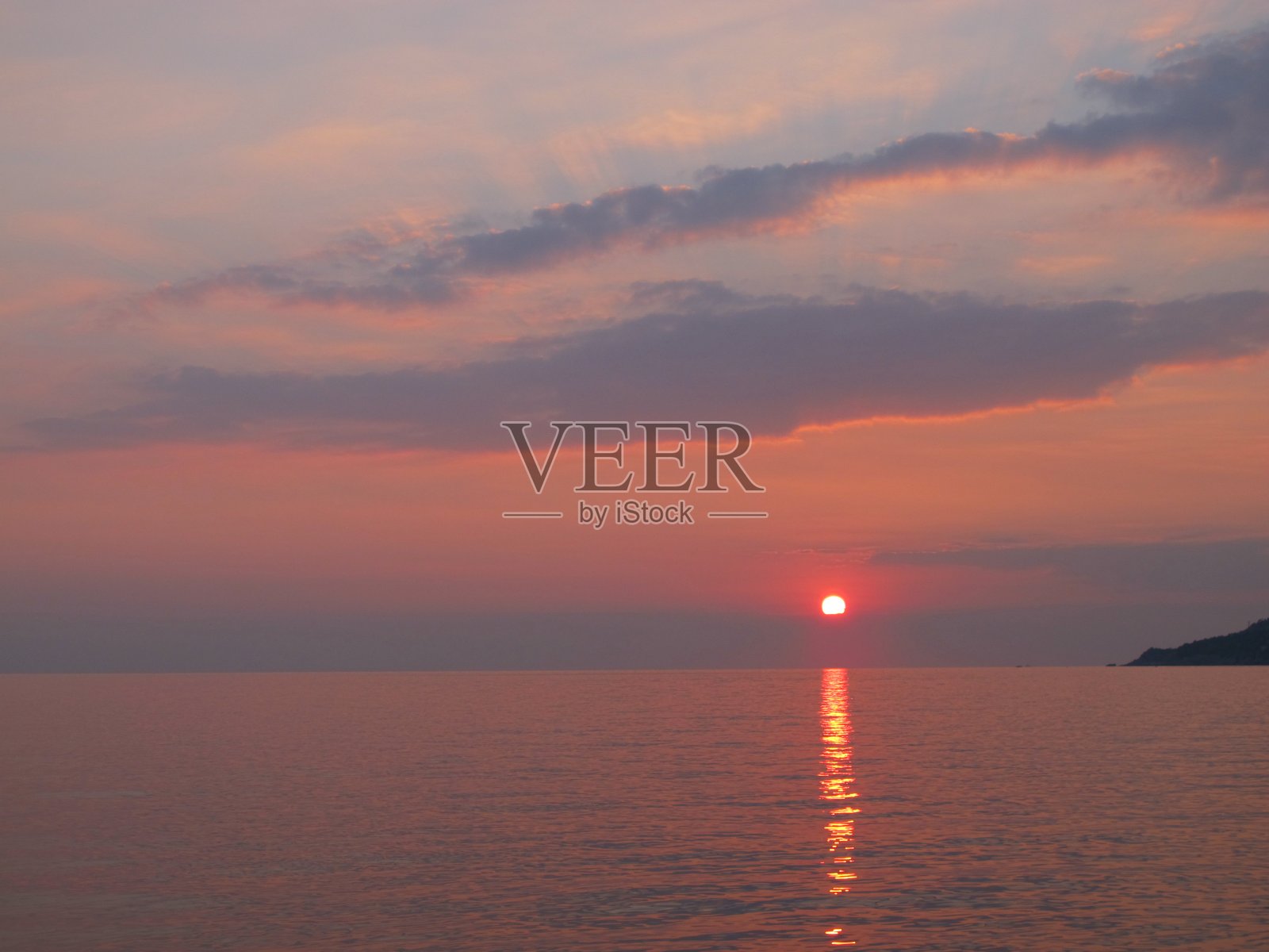 美丽的日落在海边在粉红色和淡紫色的颜色照片摄影图片