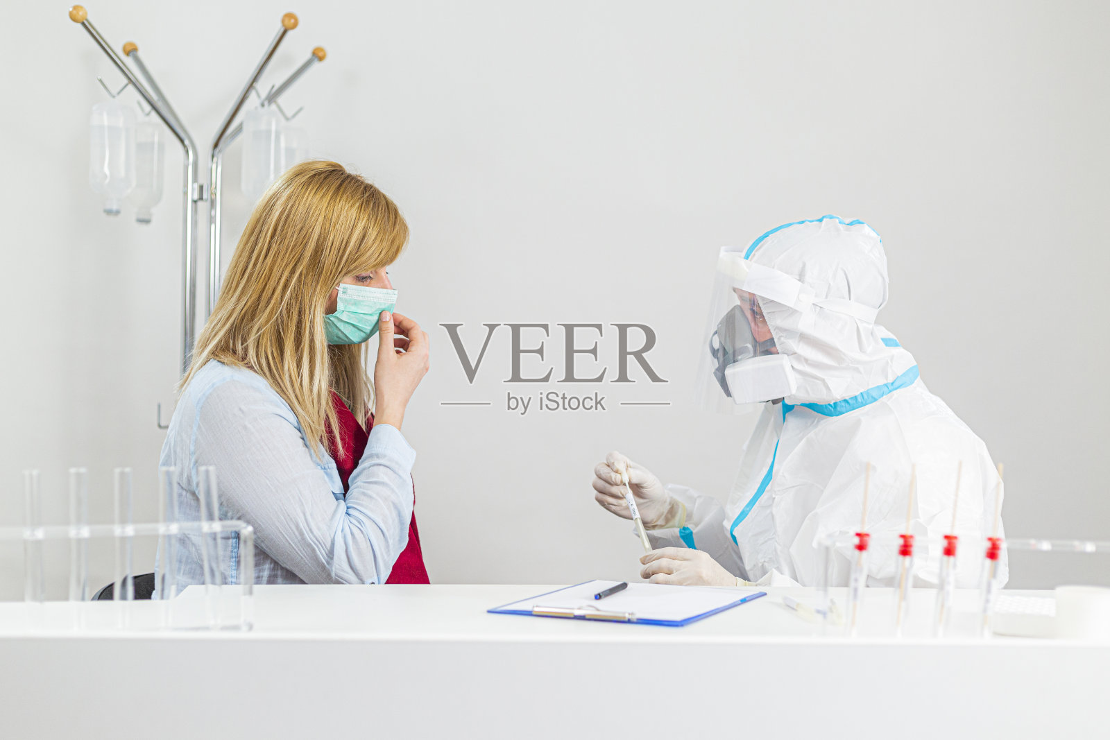 防护装备医护人员在医院实验室进行COVID-19鼻拭子检测。照片摄影图片