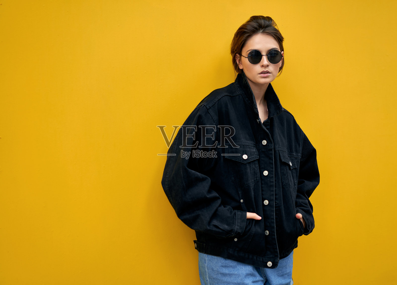 美女穿着黑色牛仔夹克,戴着墨镜照片摄影图片