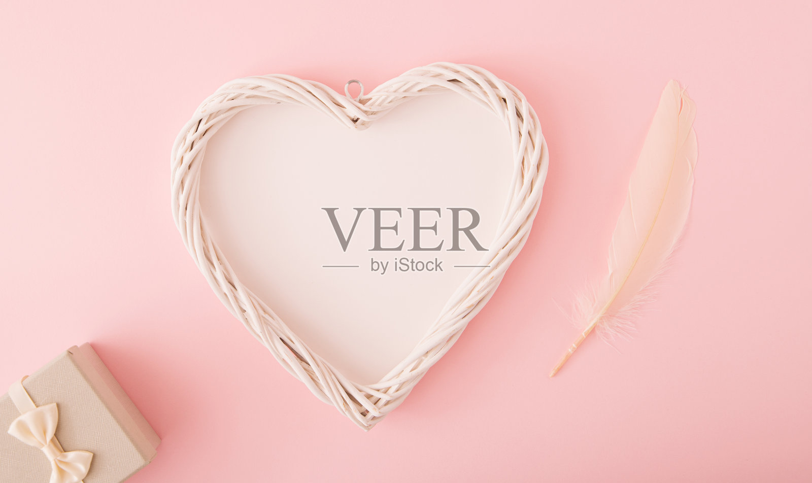 心形,有创意的复制空间,礼盒和羽毛。柔和的粉红色的颜色。平的。爱的概念。照片摄影图片