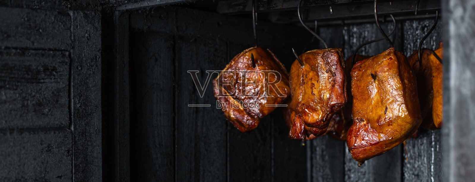 近距离的烟熏肉和腹部或山毛榉肉在烟熏室或烟熏,食物概念照片摄影图片