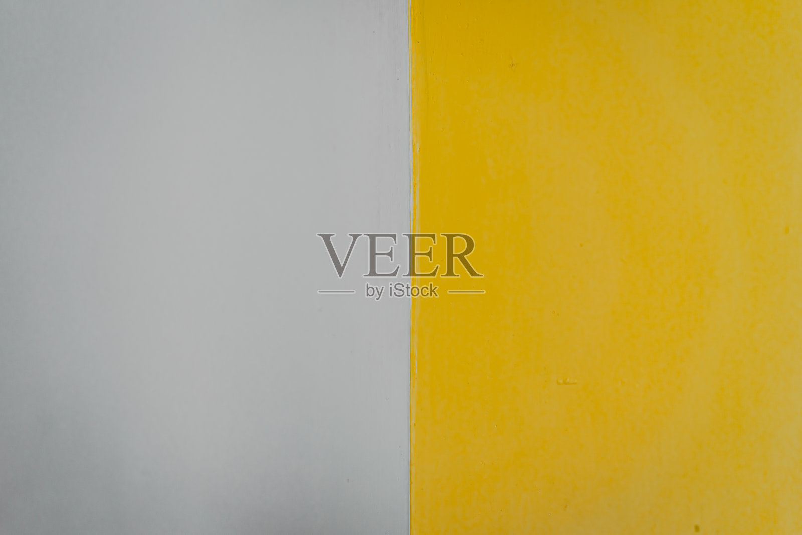 灰色和黄色的水泥墙壁表面光滑干净。照片摄影图片