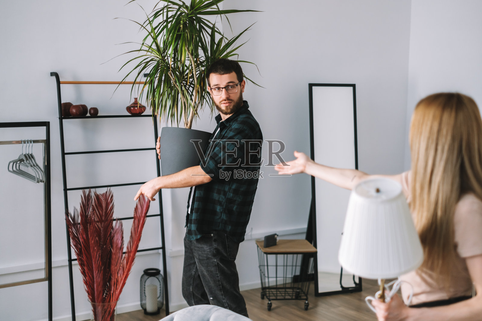 一对年轻夫妇正在翻修他们的新房,并一起搬家具。照片摄影图片