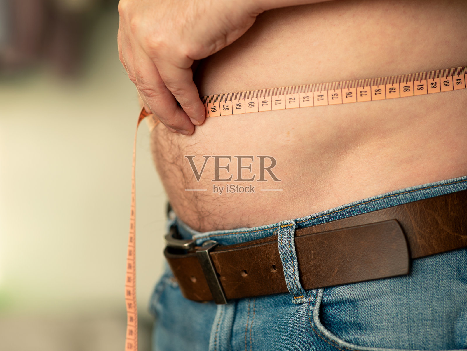 特写测量一个男人的肚子与裁缝的米照片摄影图片